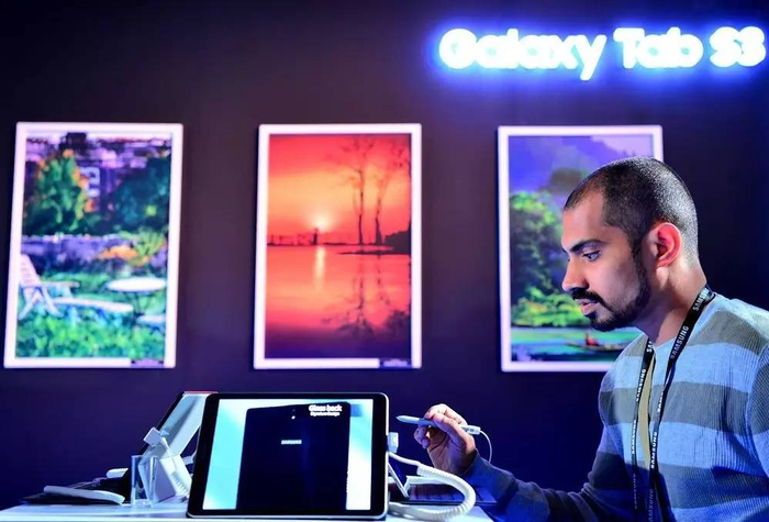  ▲资料图片：6月20日，印度班加罗尔，一名参观者在试用三星新发布的平板电脑。（法新社）