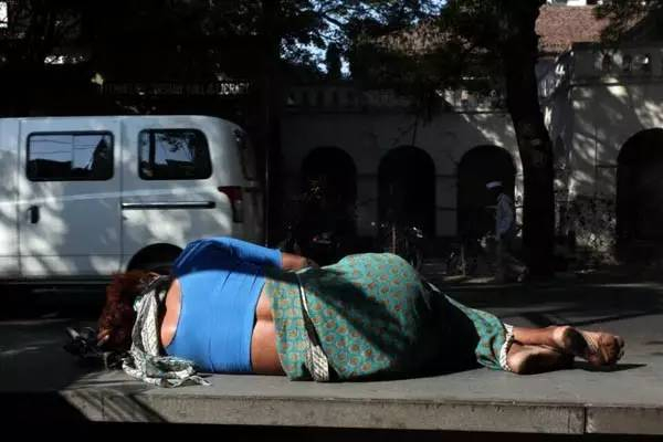 图注：在街头席地而坐、随处而卧的行人。