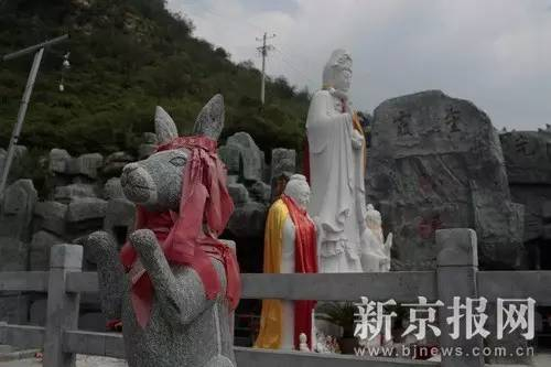 　　▲河北省易县后山奶奶庙入口，十二生肖石像身上缠满了祈愿带。远处安放着观音菩萨像、孔子像、老子像。当地的管理人员说，奶奶庙里“佛道儒不分家”。新京报记者 朱骏 摄