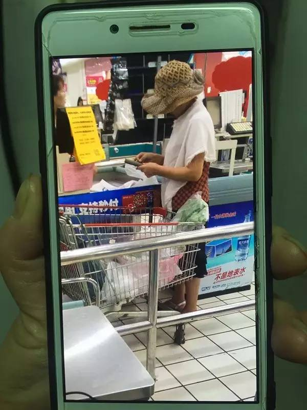 超市防损办工作人员用手机拍下了结账时的吴阿姨，3个脸盆在购物车里。