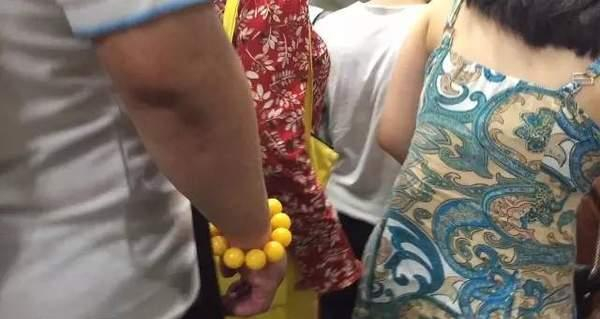 图为男子碰触另一位女士的臀部。