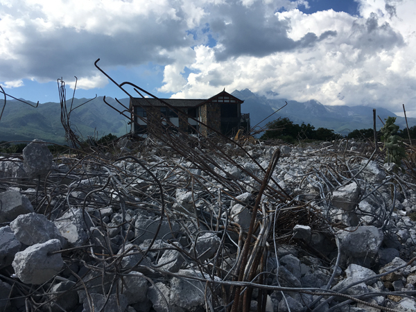院内的7栋别墅拆除后，远处只剩下当地村民的宅基地，玉龙雪山若隐若现。