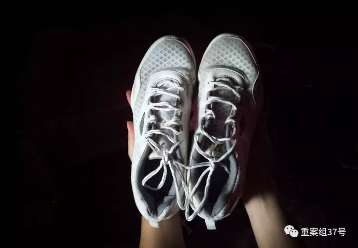 ▲8月20日，河南信阳，邓杰的母亲拿着儿子的白色球鞋。这双白色球鞋是她在广州找儿子时，在儿子的住处发现的。洗干净后带回信阳老家。