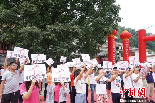 九十九名“单身狗”齐聚菩提树下，手举“我要脱单”宣言牌，高喊“我要脱单”。　贾亲亲 摄