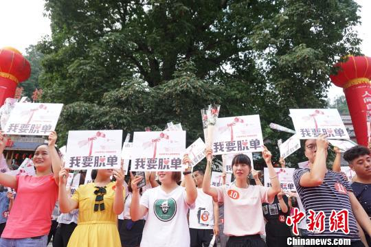 九十九名“单身狗”齐聚菩提树下，手举“我要脱单”宣言牌，高喊“我要脱单”。　贾亲亲 摄