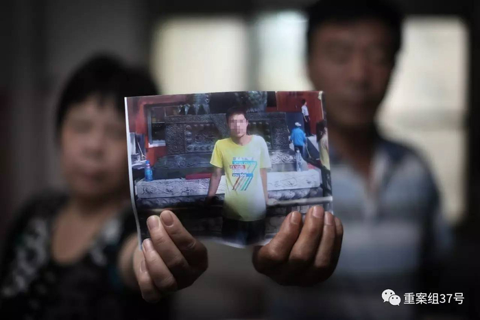 ▲8月16日上午，北京。张磊（化名）的父母拿着张磊的照片。张磊的父母九几年至今一直在北京打工。