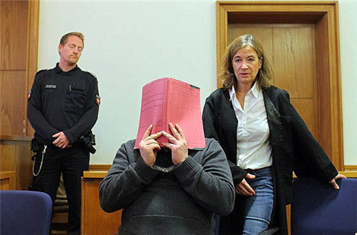 尼尔斯出庭时用文件夹挡住自己的脸