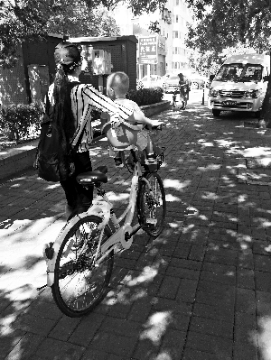 北京街头，一名家长在共享单车上装了儿童座椅。