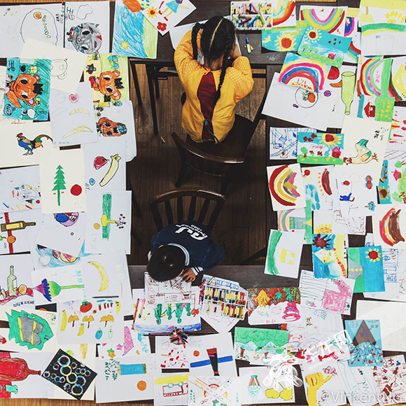 两个正在绘画的孤独症儿童。寻影季摄影工作室供图 华龙网发