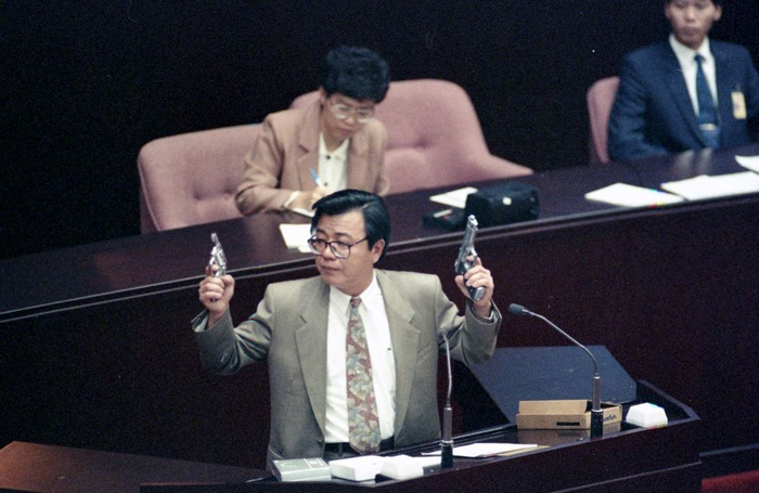  赖英芳拿手枪道具质询。（图片来源：台湾《联合报》）