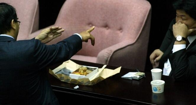  “立委”蔡豪则拿橡皮筋作势射负责监票的颜清标。（图片来源：台湾“联合新闻网”）