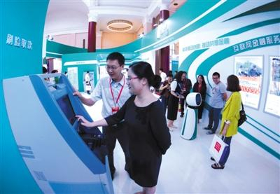 消费者在农业银行取款机前体验“刷脸取款”。图片来源：新京报