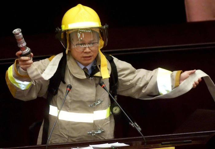  “立委”林政则背着30多公斤的消防队员设备，呼吁大家应向辛苦的“打火英雄”致敬。（图片来源：台湾《联合报》）