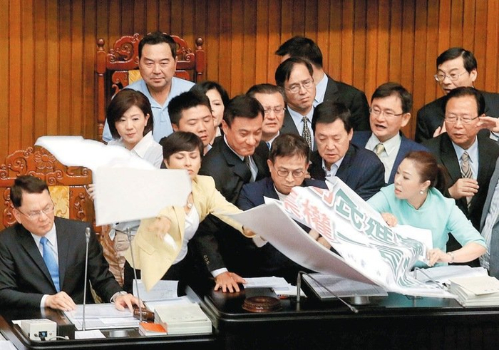  国民党“立委”不满，拿抗议海报占领主席台，蓝绿“立委”爆冲突。（图片来源：台湾《经济日报》）