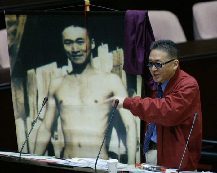  李敖质询时拿出年轻时的裸照，表示坚决反对军购。（图片来源：台湾《联合报》）