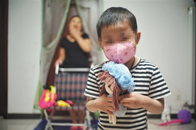 畅畅抱着医院护士送的娃娃，她喜欢娃娃的长发，也向往自己能留起长发。