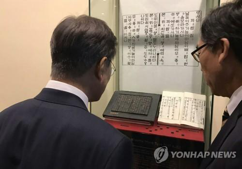 　　资料图片：文在寅（左）在出席联大期间参观陈列于联合国总部的《月印千江之曲》。（图片来源：韩联社）