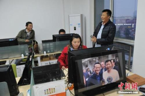 资料图：农民电商与加班的员工聊天。 中新社记者 韦亮 摄