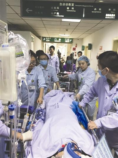 抢救成功后，医生们为张明礼转病房。成都商报 图