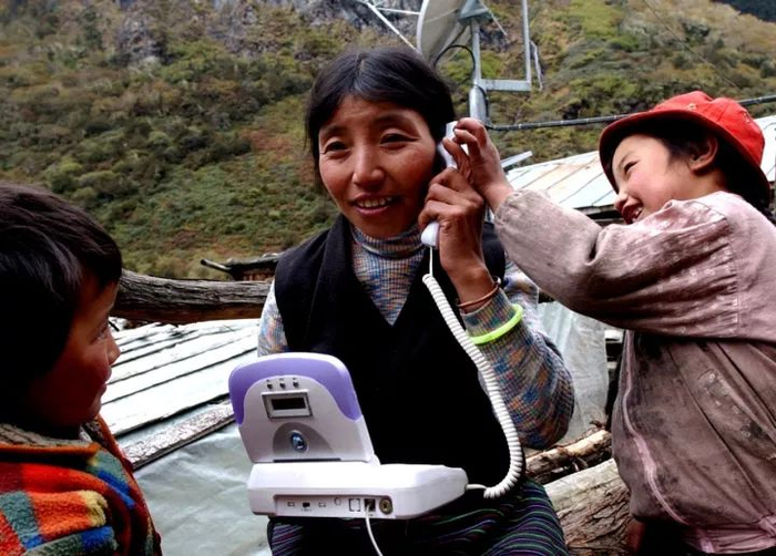 2003年10月，卓嘎与孩子们一起从家乡给在山外的朋友打电话。