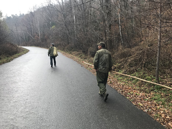 张辉背着脚扎子背着麻袋走在前面，拿着长杆的同伴负责捡塔。澎湃新闻记者 沈文迪 图