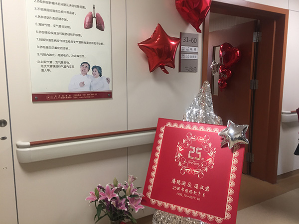 病房门口放置了夫妻俩25周年银婚纪念仪式的展板。