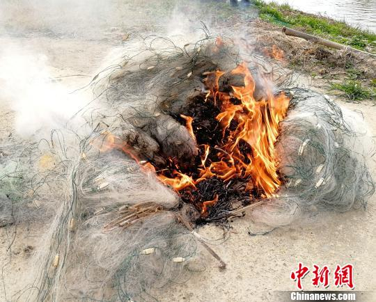 　　近日，江西鄱阳湖国家级自然保护区管理局工作人员在大湖池保护区巡护时，烧毁缴获的渔网。（资料图） 周云南 摄
