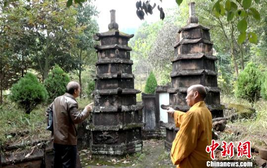 龙岩寺住持（右）向文史专家介绍双子墓塔。　徐志雄 摄