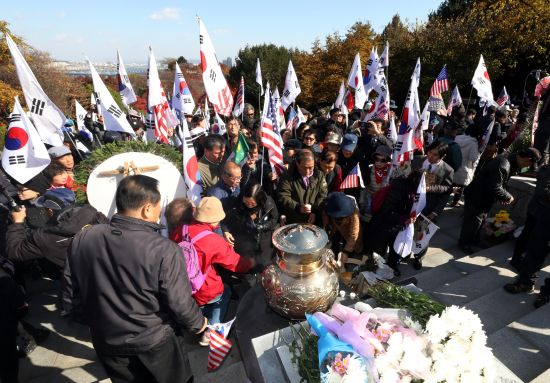 14日，韩国民众手挥太极旗星条旗参加纪念活动