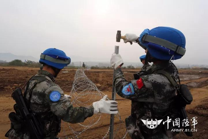 陆军第83集团军某合成旅步兵营在确山基地开展以武装分子发生交火为背景的维和营地安全防卫演练。图为修建维和营地防护铁丝网。