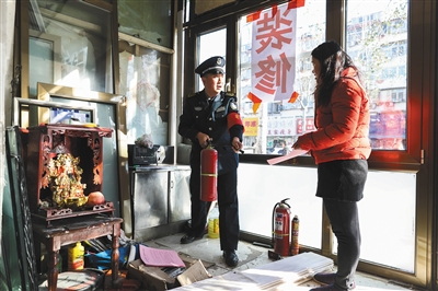 11月26日，石景山鲁谷七星园南社区，“老街坊”防消队队员、十九大代表贾树庆在指导商户用灭火器。新京报记者 浦峰 摄