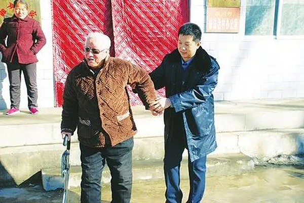 柴晓飞在村委会大院送体检完的老人回家。郭瑞摄 资料图