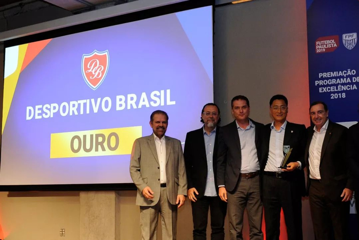 　　鲁能巴西体育中心获得巴西圣保罗州职业俱乐部优秀青训金奖，圣保罗州足协主席巴斯托斯（左一）颁奖。鲁能巴西体育中心供图