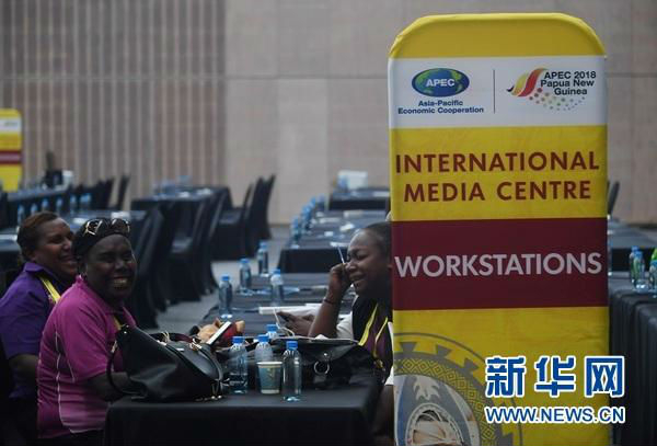 11月11日，在位于巴新莫尔兹比港的APEC新闻中心，工作人员面带笑容。（新华社）