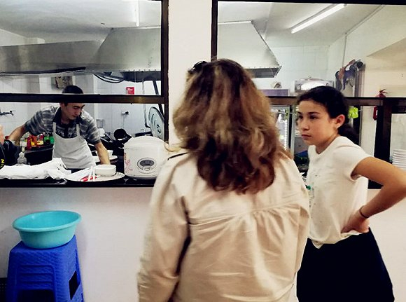 观赏后厨师傅拉面工艺的印尼母女。摄影：侯瑞宁