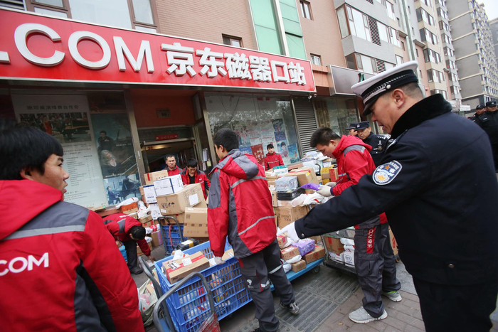 城管执法人员对快递点占道行为进行劝导。 供图：东城城管