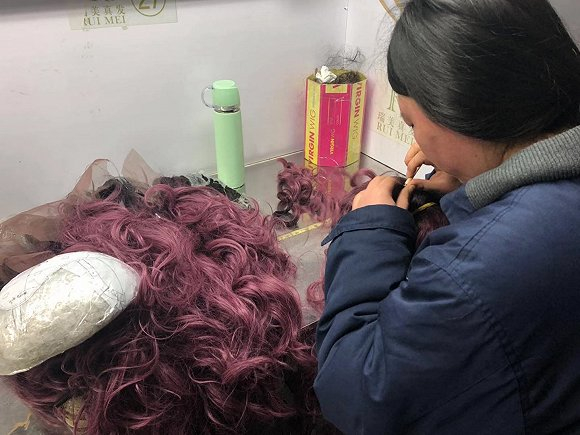 正在将假发勾到发网上的工人。图片拍摄：刘雨静