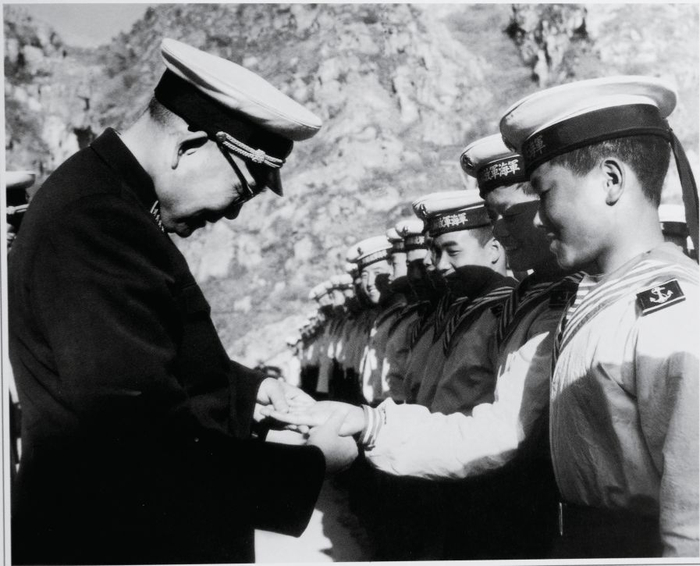 1964年5月，萧劲光在旅顺看望海军战士们，关心地查看战士手上的伤口。