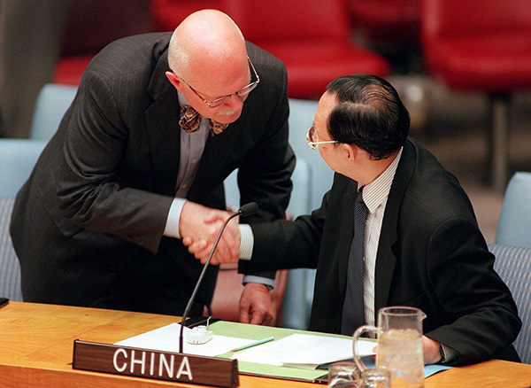 1999年5月8日，联合国安理会成员聚集在纽约联合国总部，进行一次由北京召集的紧急会议，讨论中国驻贝尔格莱德大使馆遭北约空袭一事。图为美国代办彼得·伯利问候时任中国大使秦华孙。视觉中国 资料