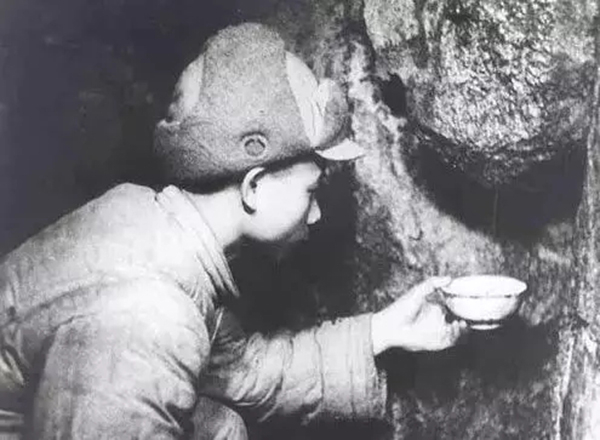 志愿军模范卫生员、特等功臣陈振安，将石缝里流出来的水一滴滴接下来给伤员喝。