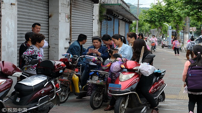 　　▲2016年5月19日，浙江省舟山市，东海小学外接小孩放学的家长凑在一起议论“疯狗伤人事件”。图片来自视觉中国。