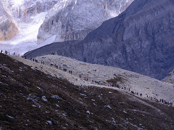 旅游高峰期，每天向景区海拔4600米以上景点攀登的游客绵延数公里。