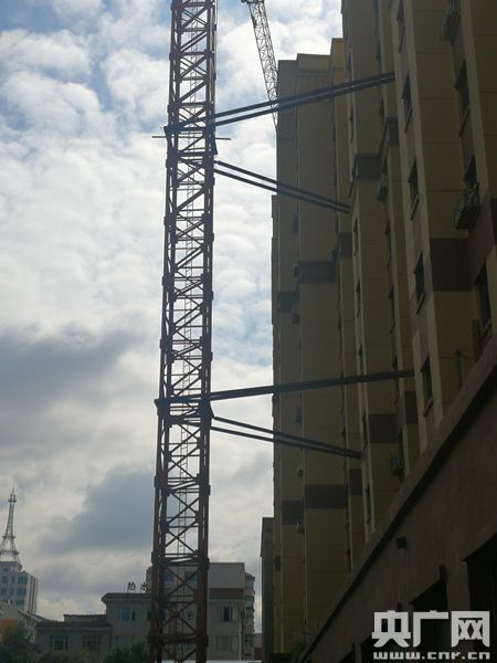 塔吊矗立在已入住的新楼前。（央广记者 刘源源 摄）