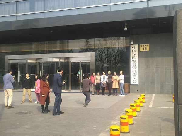  3月21日下午，更换门牌在即，保监会门口众多工作人员拍照留念。 杨峰 摄