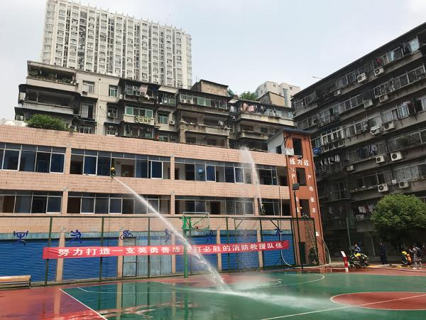 　　江汉中队训练场旁，就是居民楼，消防员演练在老旧小区架设水带灭火。 本文图片&nbsp;澎湃新闻记者 周琦