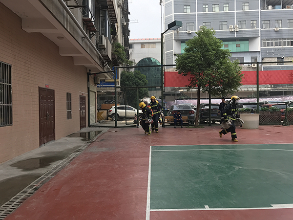消防队员们从大街架设水带到训练场。