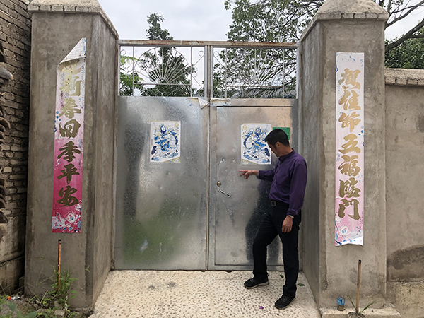  唐加勇在家门口介绍当晚发生的情况。