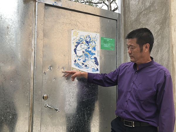  李德湘当晚拿着菜刀砍砸唐家大门留下的痕迹处，还有警方勘查的标记。