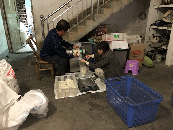 邓自和夫妇合作将切好的米粉装袋。澎湃新闻记者 钟笑玫 图