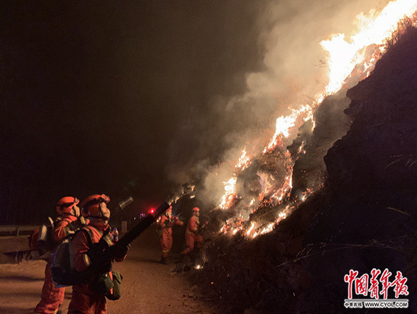 　消防指战员正在用风力灭火机引导火势“以火攻火”。中国青年报 图